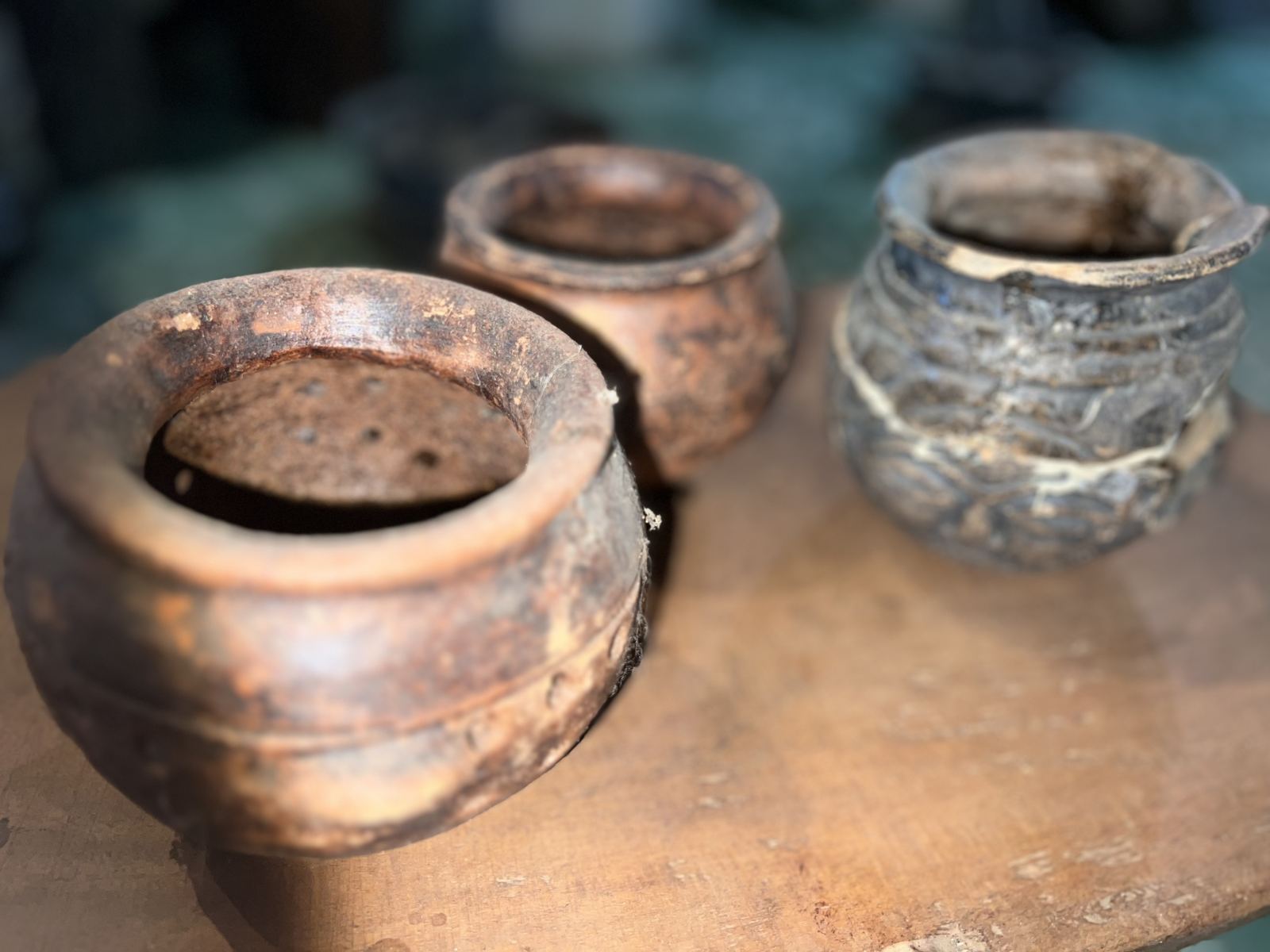 Trois petits pots en terre cuite, dont un brûle-encens perforé